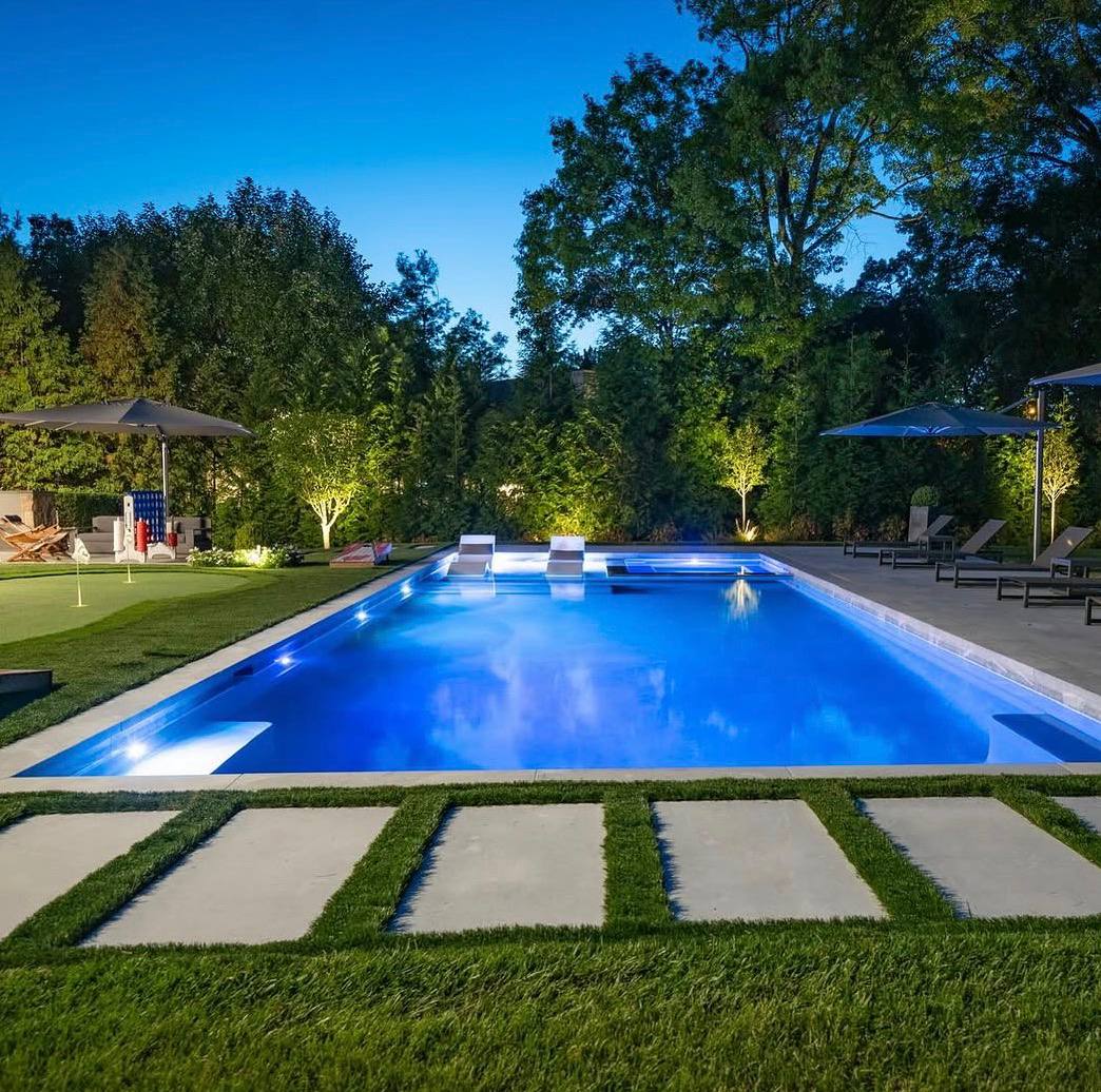 Large luxury pool at night with putting green